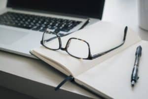 Notebook, Schreibkladde und Brille