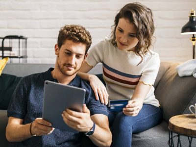 Junges Paar beim Online-Shopping mit Tablet und Kreditkarte